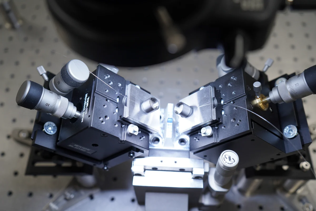 Optical fibres held by precision alignment stages on a laboratory bench